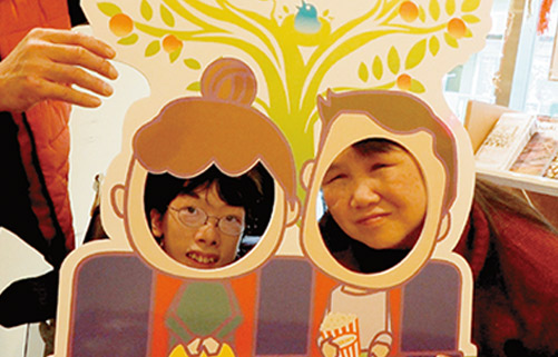 シネマ・チュプキ・タバタの顔出しパネルに顔を出す石田監督と美月さん